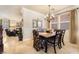 Dining room featuring travertine floors, elegant chandelier, and large windows for natural light at 1163 Highbury Grove St, Henderson, NV 89002