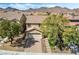 Charming two-story house with a brick driveway, mature trees, and mountain backdrop at 1163 Highbury Grove St, Henderson, NV 89002