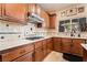 Close up of kitchen details with wooden cabinets, granite countertops, and stainless steel appliances at 1163 Highbury Grove St, Henderson, NV 89002