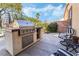 Outdoor kitchen on a patio with stainless steel appliances and a built-in grill at 1163 Highbury Grove St, Henderson, NV 89002