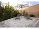 Relaxing backyard patio with lush greenery, stylish lounge chairs, and an umbrella for shade at 11895 Skyline Arch Ct, Las Vegas, NV 89138