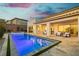 Evening view of the backyard pool and patio with seating area, surrounded by lush landscaping and serene ambiance at 11895 Skyline Arch Ct, Las Vegas, NV 89138