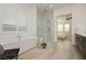 Bright bathroom featuring a soaking tub, glass shower, dual vanities, and access to the main bedroom at 11895 Skyline Arch Ct, Las Vegas, NV 89138