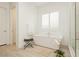 Bright bathroom with a freestanding tub, a large window with shutters, and tile floors at 11895 Skyline Arch Ct, Las Vegas, NV 89138