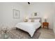 Cozy bedroom with white bedding, modern decor, and a patterned rug on light wood floors at 11895 Skyline Arch Ct, Las Vegas, NV 89138