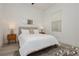 Cozy bedroom with white bedding, modern decor, and a patterned rug on light wood floors at 11895 Skyline Arch Ct, Las Vegas, NV 89138