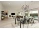 Bright dining area open to living room with modern chandelier and access to outdoor pool area at 11895 Skyline Arch Ct, Las Vegas, NV 89138