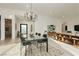 Open-concept dining room showcases a modern chandelier, a glass table for six, and bright natural lighting at 11895 Skyline Arch Ct, Las Vegas, NV 89138