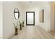 Modern hallway with light wood floors, a black front door, and minimalist decor at 11895 Skyline Arch Ct, Las Vegas, NV 89138