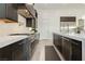 Modern kitchen with stainless steel appliances, custom cabinetry, white marble countertops, and wood floors at 11895 Skyline Arch Ct, Las Vegas, NV 89138