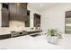 Bright kitchen with white countertops, dark cabinets, stainless steel appliances and a modern sink at 11895 Skyline Arch Ct, Las Vegas, NV 89138