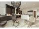 Stylish kitchen area with granite countertops, dark wood cabinets, and a unique light fixture at 11895 Skyline Arch Ct, Las Vegas, NV 89138