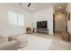 Living room features bright window, TV, contemporary decor, ceiling fan and view to kitchen at 11895 Skyline Arch Ct, Las Vegas, NV 89138