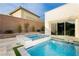 Relaxing pool and hot tub combination with modern tile work, landscaping, and seamless access to the house through sliding glass doors at 11895 Skyline Arch Ct, Las Vegas, NV 89138