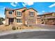 Two-story tan house with a three-car garage and a well-manicured lawn on a sunny day at 1220 Earth Ct, North Las Vegas, NV 89032