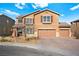 Two-story tan house with a three-car garage and a well-manicured lawn on a sunny day at 1220 Earth Ct, North Las Vegas, NV 89032