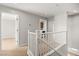 Upstairs hallway with white railing and neutral carpet at 1220 Earth Ct, North Las Vegas, NV 89032