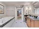 Well-lit bathroom featuring a soaking tub and a vanity with black granite countertops at 135 E Harmon Ave # 2601&2603, Las Vegas, NV 89109