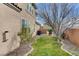 A backyard with a tree, green grass, rock landscaping, and a brick perimeter at 1381 Robard St, Las Vegas, NV 89135