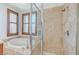 Close-up of bathroom with soaking tub with tiled platform and glass-enclosed shower stall at 1381 Robard St, Las Vegas, NV 89135