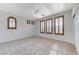 Bright bedroom features neutral carpet, a ceiling fan, and shuttered windows at 1381 Robard St, Las Vegas, NV 89135