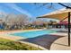 Outdoor swimming pool with shade structures, surrounded by well-maintained landscaping, perfect for summer relaxation at 1381 Robard St, Las Vegas, NV 89135