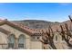 Exterior view showcases a beige two-story home with a clay tile roof, arched windows, and mountain views at 1381 Robard St, Las Vegas, NV 89135