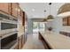 Wide angle of kitchen island, wooden cabinets, and stainless double oven at 1381 Robard St, Las Vegas, NV 89135