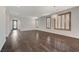 Open concept living room boasting dark wood floors, white walls, shuttered windows, and modern light fixtures at 1381 Robard St, Las Vegas, NV 89135