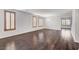 Spacious open concept living room featuring dark wood floors, white walls, and shuttered windows at 1381 Robard St, Las Vegas, NV 89135