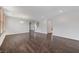 Spacious open concept living room featuring dark wood floors, white walls, an arched doorway, and staircase at 1381 Robard St, Las Vegas, NV 89135