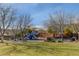 Community playground with slides, benches, mature trees, and grassy area under a bright blue sky at 1381 Robard St, Las Vegas, NV 89135