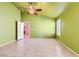 Bright bedroom featuring a ceiling fan, tile flooring, plantation shutters, and a view into the hallway at 1424 Desert Hills Dr, Las Vegas, NV 89117