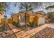 Attractive single-story home with a red tile roof, palm tree accents, and a two-car garage in a landscaped setting at 1424 Desert Hills Dr, Las Vegas, NV 89117