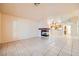 Open-concept living room with tiled flooring, a fireplace, and an adjacent kitchen area, perfect for entertaining at 1424 Desert Hills Dr, Las Vegas, NV 89117