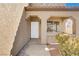 Home's stucco facade features a white door and covered porch at 1444 Country Hollow Dr, Las Vegas, NV 89117