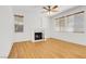 Bright living room with hardwood floors, a ceiling fan, windows with blinds, and a cozy fireplace at 1444 Country Hollow Dr, Las Vegas, NV 89117