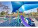 Colorful community playground features slides and climbing structures under a blue canopy at 1444 Country Hollow Dr, Las Vegas, NV 89117