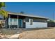 Mid-century modern home with gray siding and a teal front door, showcasing curb appeal at 207 W Victory Rd, Henderson, NV 89015