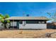 Ranch style home with dark gray siding, white rock accents, and a teal front door at 207 W Victory Rd, Henderson, NV 89015