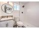 This bathroom features a white vanity with marble countertops, a black circular mirror and tiled shower at 2133 Linden Tree St, Las Vegas, NV 89156