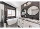 Modern bathroom with double vanity, freestanding tub, and elegant black and white design at 2133 Linden Tree St, Las Vegas, NV 89156