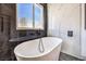 Modern bathroom features a soaking tub with black hardware set against elegant tile at 2133 Linden Tree St, Las Vegas, NV 89156