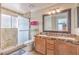 Well-lit bathroom with a double sink vanity, a large mirror, and a glass-enclosed shower at 2153 Hookcross Cir, Henderson, NV 89074