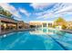 Community pool with blue water, lounge chairs, and shaded seating areas under a clear blue sky at 2401 Rockford St, Las Vegas, NV 89134