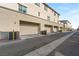 View of the garages of the townhouse complex with clean asphalt and light-colored walls on a bright day at 2844 Copper Wind Ln # 4, Las Vegas, NV 89183