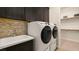 Functional laundry area featuring modern appliances, ample cabinet space, and convenient utility sink at 29 Faro De Marbella Ct, Henderson, NV 89011