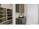 Neutral mud room with overhead cabinets, lower cabinets, open shelving, and a white door at 29 Faro De Marbella Ct, Henderson, NV 89011