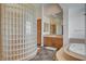 Bathroom featuring a tiled floor, soaking tub, glass block shower, vanity, and linen closet at 3 Chenal Pass, Henderson, NV 89052