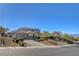 An exterior elevation of the home's entrance shows the front yard, manicured bushes and a circular driveway at 3 Chenal Pass, Henderson, NV 89052